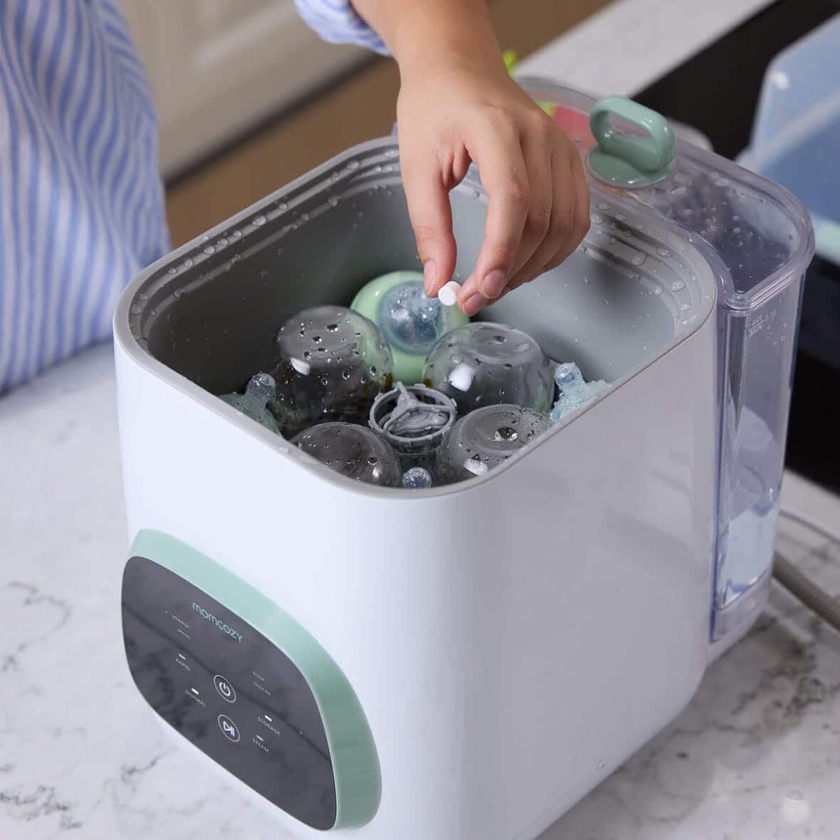 Pastille de lavage Momcozy dans le compartiment du lave-biberons KleanPal Pro
